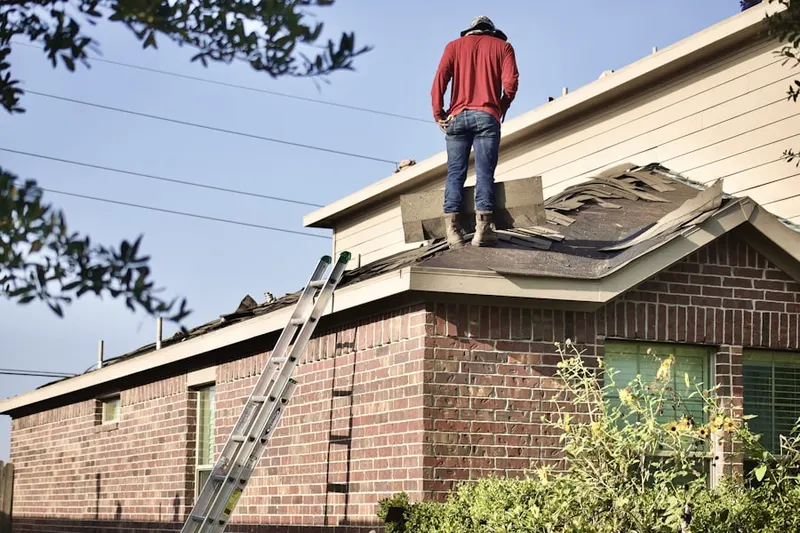 Professional roofer working on a residential roof in Red Valley